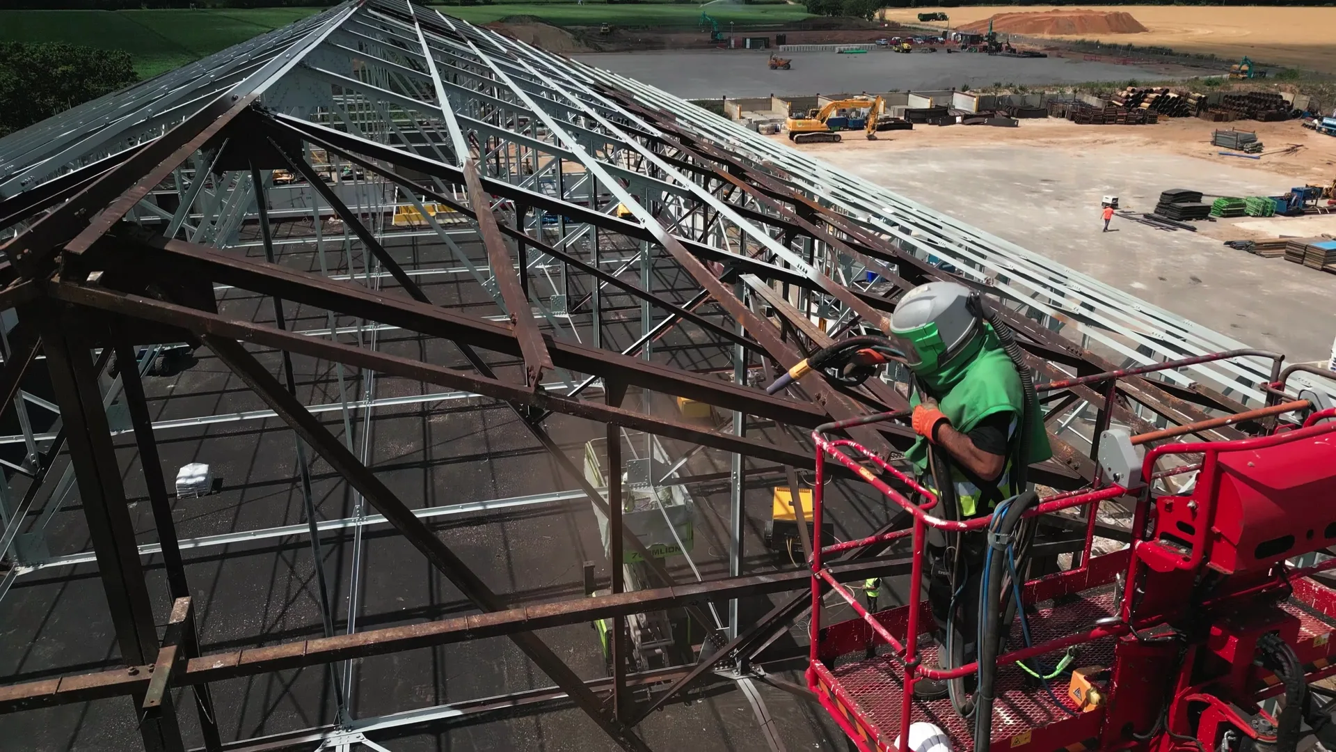 Premier Blasting operative applying a protective coating to structural steel from powered access equipment.
